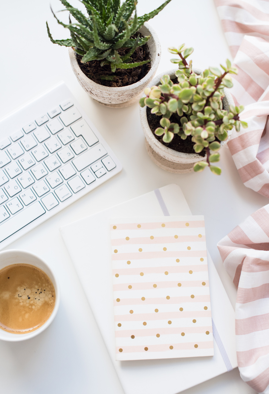 Flat Lay of Feminine Workplace with Coffee Cup, Keyboard, Notebooks and Plants